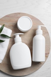 Photo of Different cosmetic products and towel on white wooden table, top view