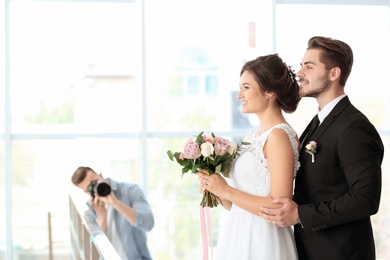 Photo of Professional photographer taking photo of wedding couple in studio