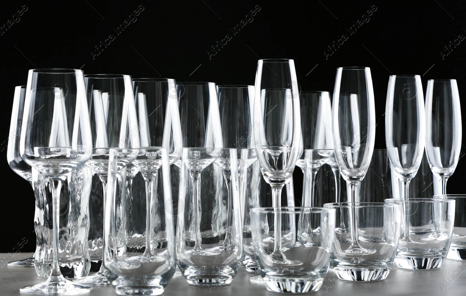 Photo of Set of empty glasses on table against black background