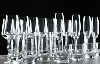 Set of empty glasses on table against black background