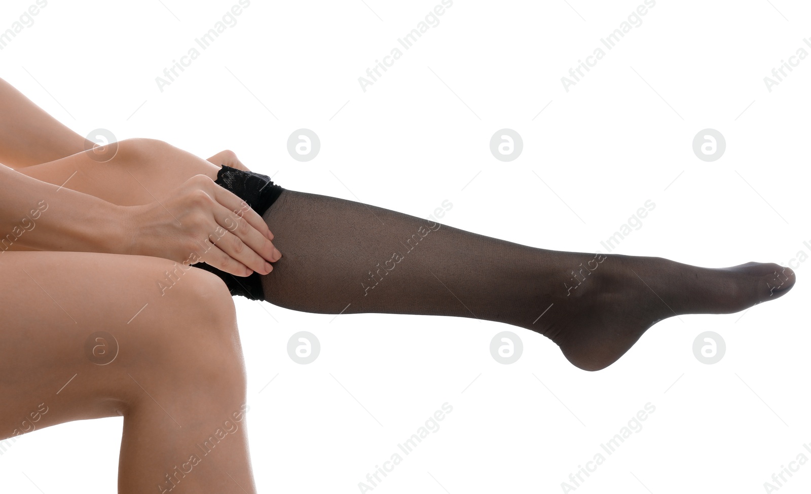 Photo of Young woman putting on stocking against white background, closeup