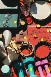 Photo of Many different items on table outdoors, above view. Garage sale