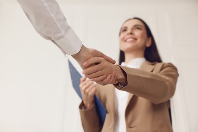 Photo of Human resources manager shaking hands with applicant during job interview in office, selective focus