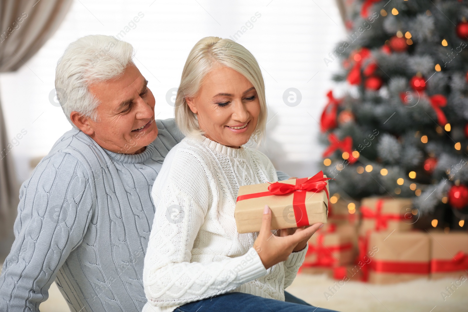 Photo of Happy mature couple with Christmas gift at home