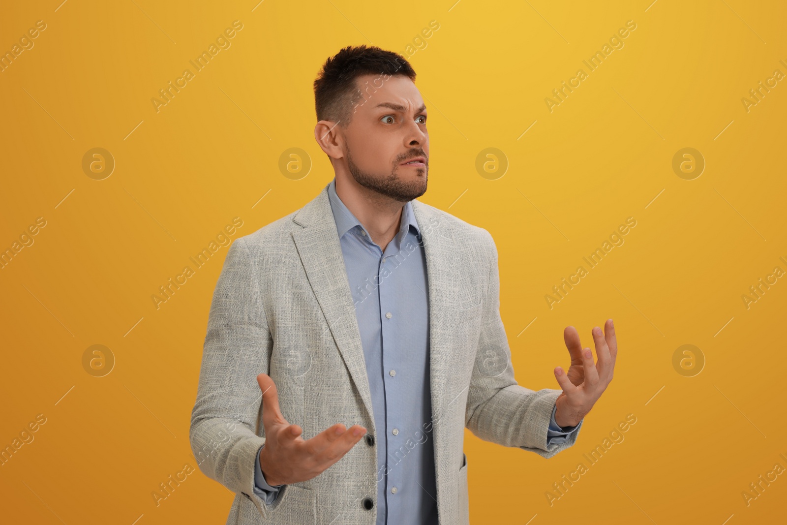 Photo of Angry man on yellow background. Hate concept