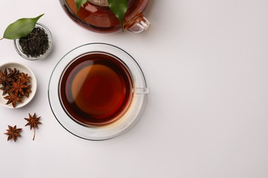 Photo of Flat lay composition with aromatic tea and anise stars on white table. Space for text