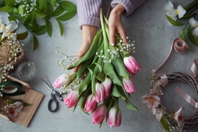 Female decorator creating beautiful bouquet at table