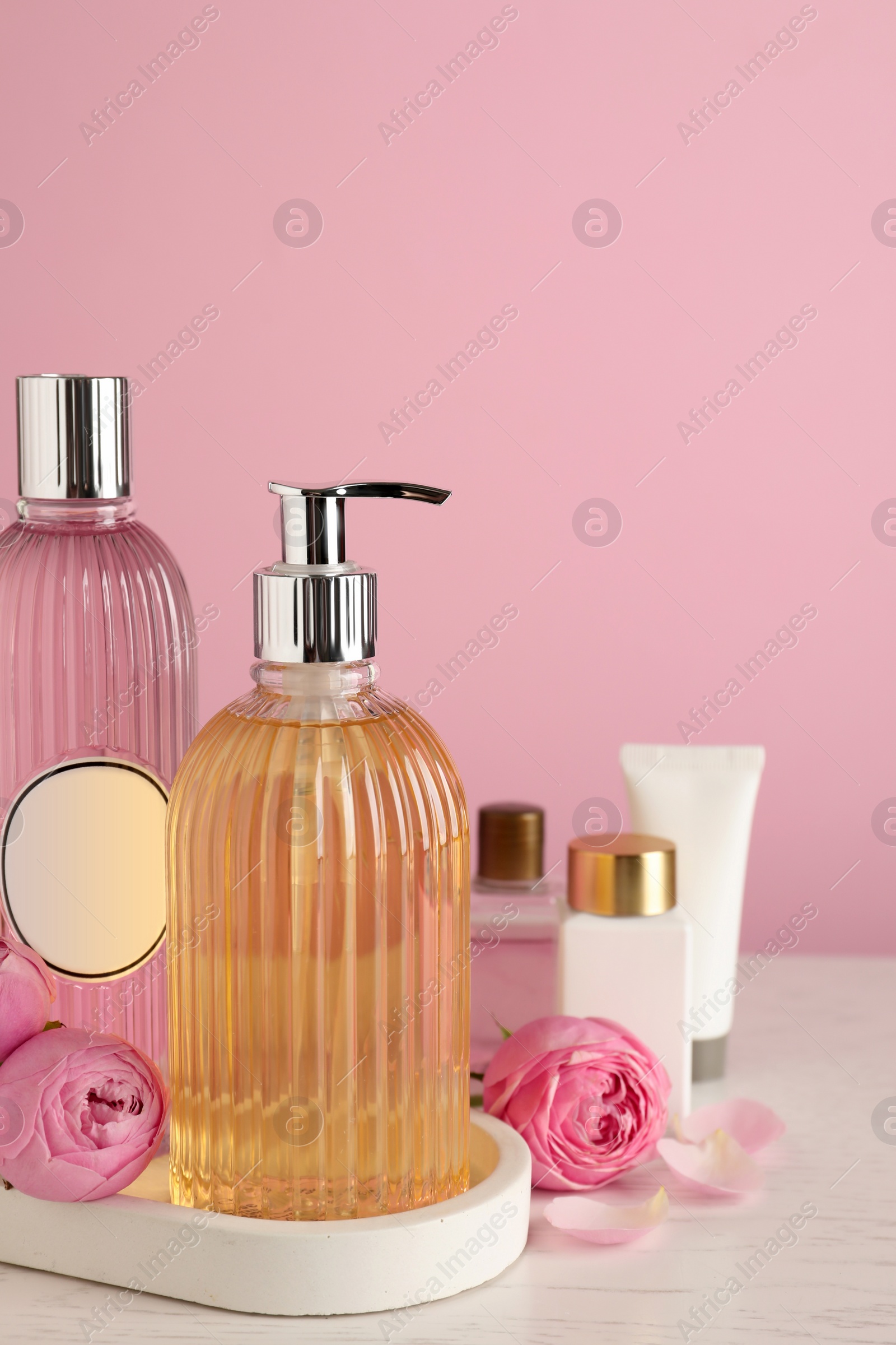 Photo of Cosmetic products and flowers on white wooden table