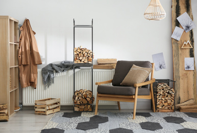 Photo of Stylish room interior with firewood as decorative element