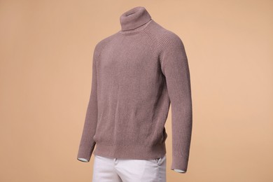 Photo of Male mannequin dressed in stylish turtleneck and pants on beige background