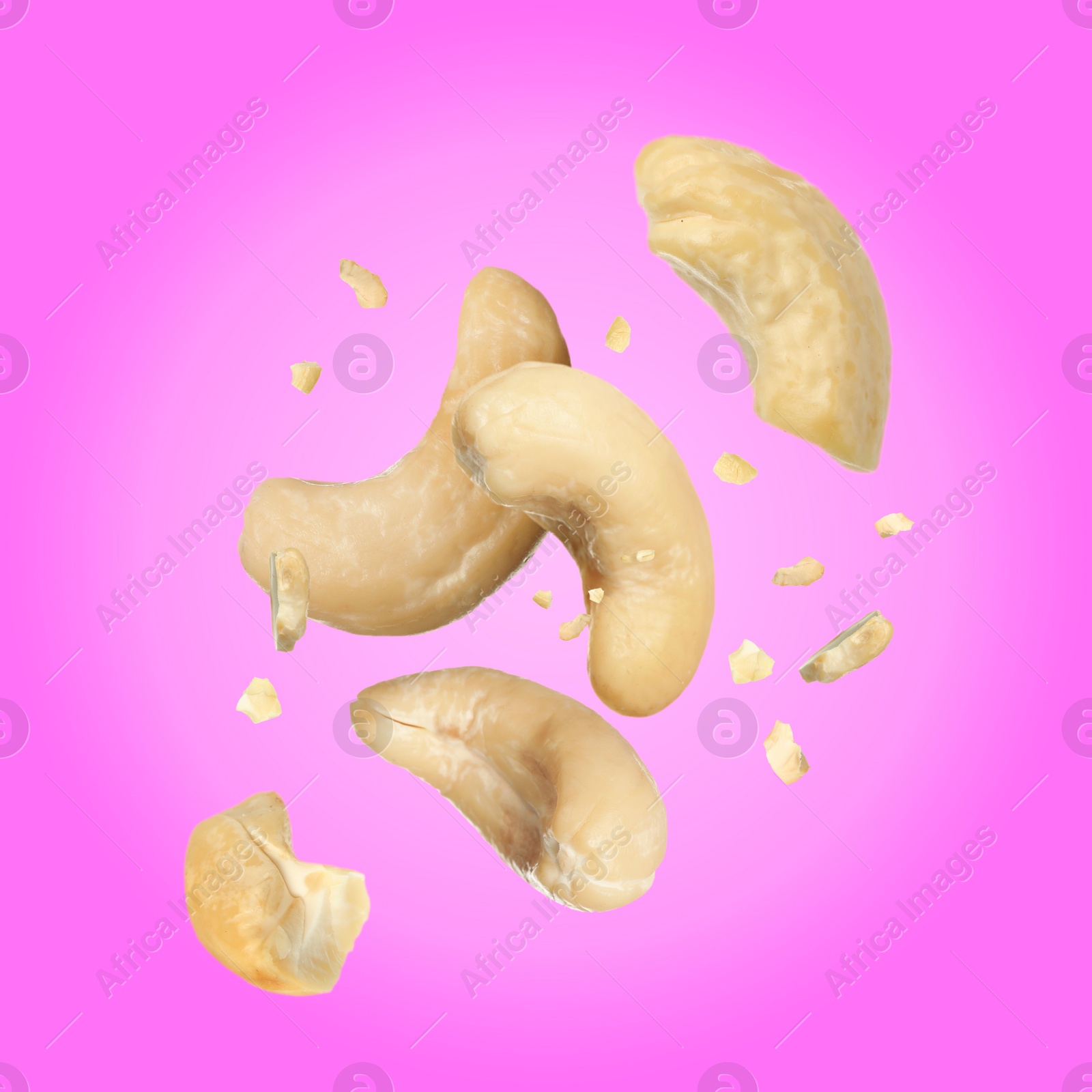 Image of Tasty cashew nuts flying on pink background