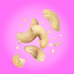 Image of Tasty cashew nuts flying on pink background