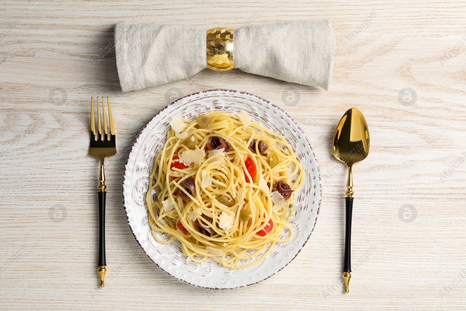 Photo of Delicious pasta with anchovies, tomatoes and parmesan cheese served on white wooden table, flat lay