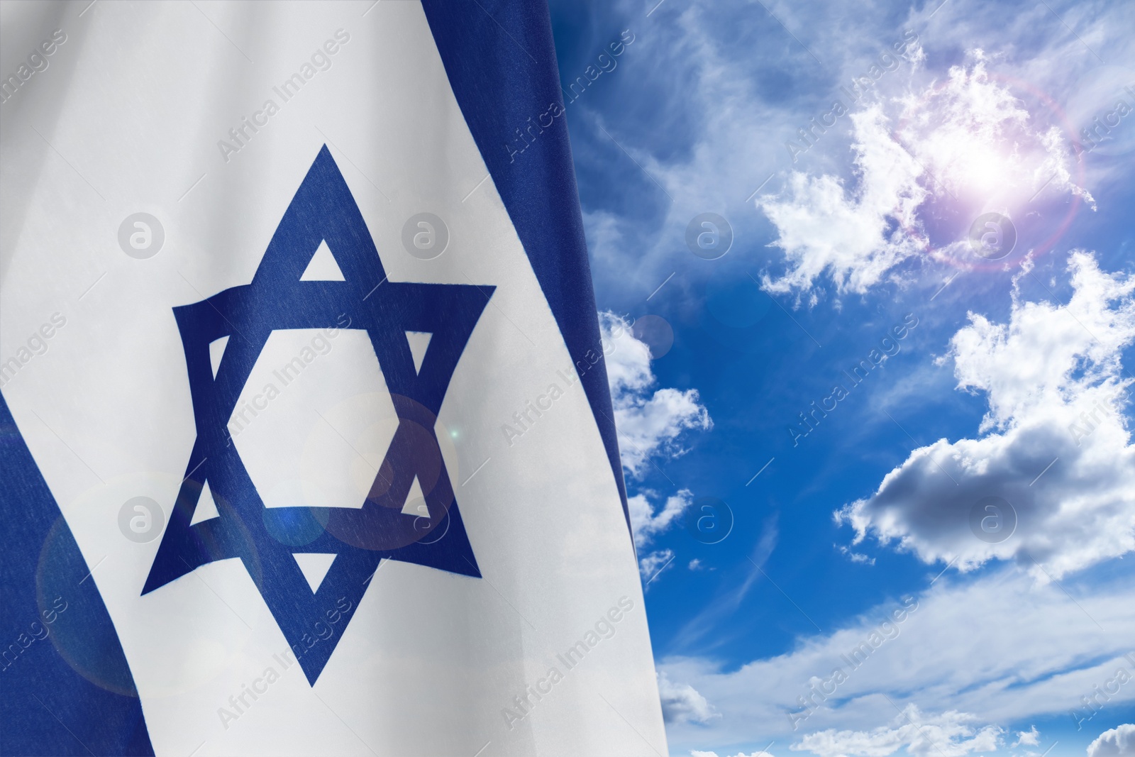 Image of National flag of Israel against blue sky with clouds