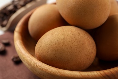 Easter eggs painted with natural dye in wooden bowl, closeup