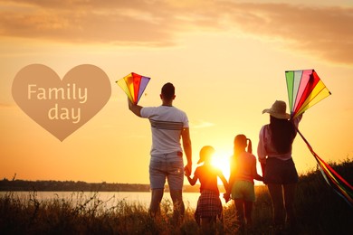 Parents and their children playing with kites outdoors at sunset, back view. Happy Family Day 
