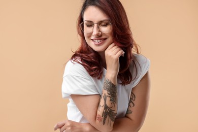 Photo of Portrait of beautiful tattooed woman on beige background
