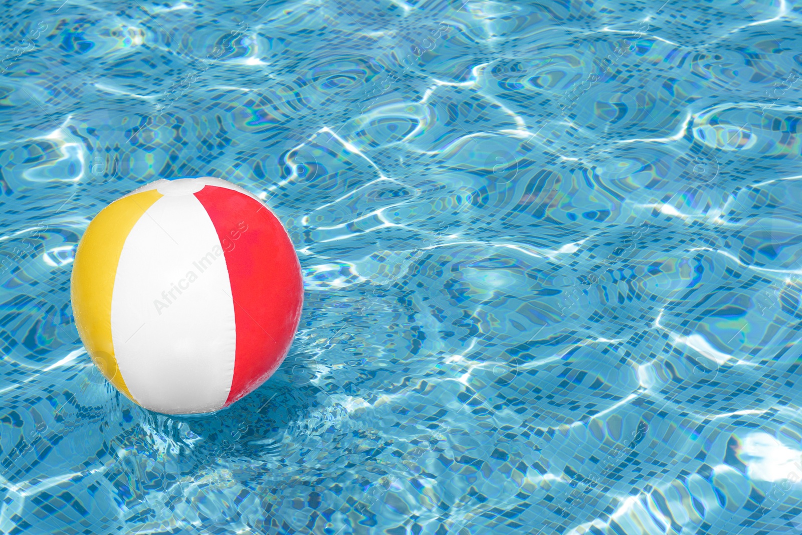 Photo of Inflatable beach ball floating in swimming pool, space for text