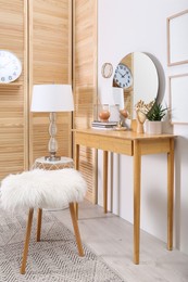 Photo of Modern wooden dressing table with mirror and stool in room