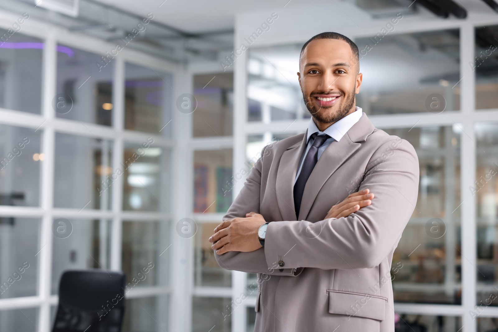 Photo of Happy man with crossed arms in office, space for text. Lawyer, businessman, accountant or manager