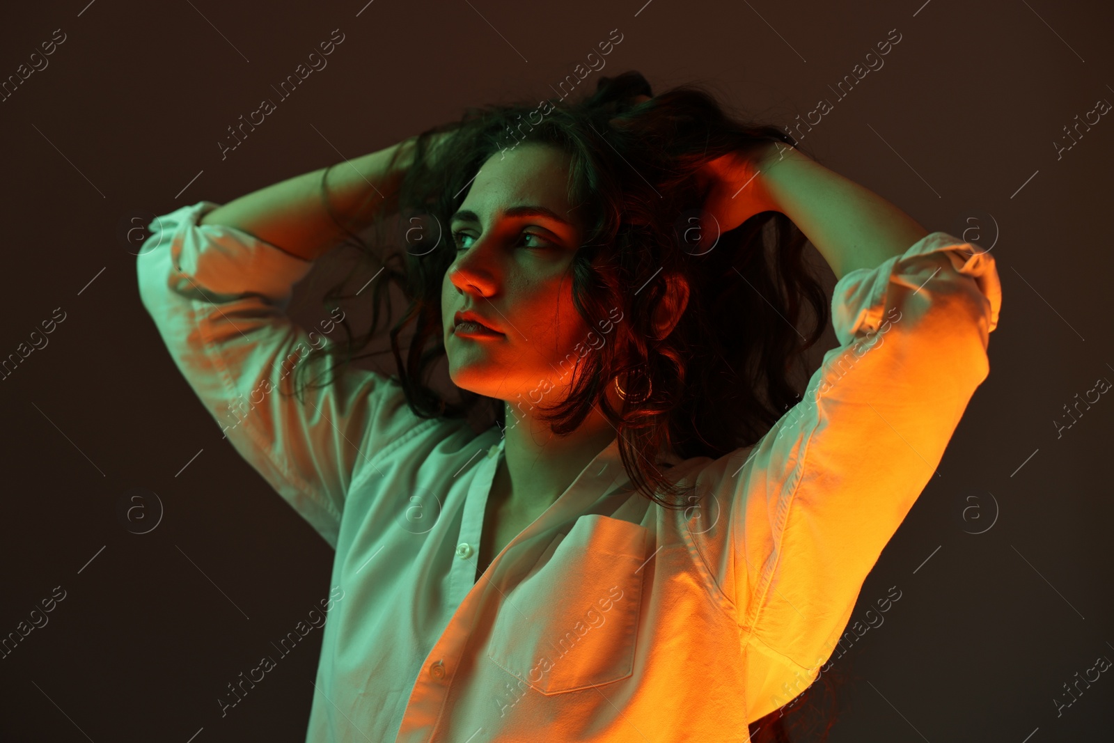 Photo of Portrait of beautiful young woman on color background with neon lights