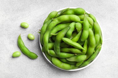 Photo of Green edamame beans in pods on light grey table, flat lay