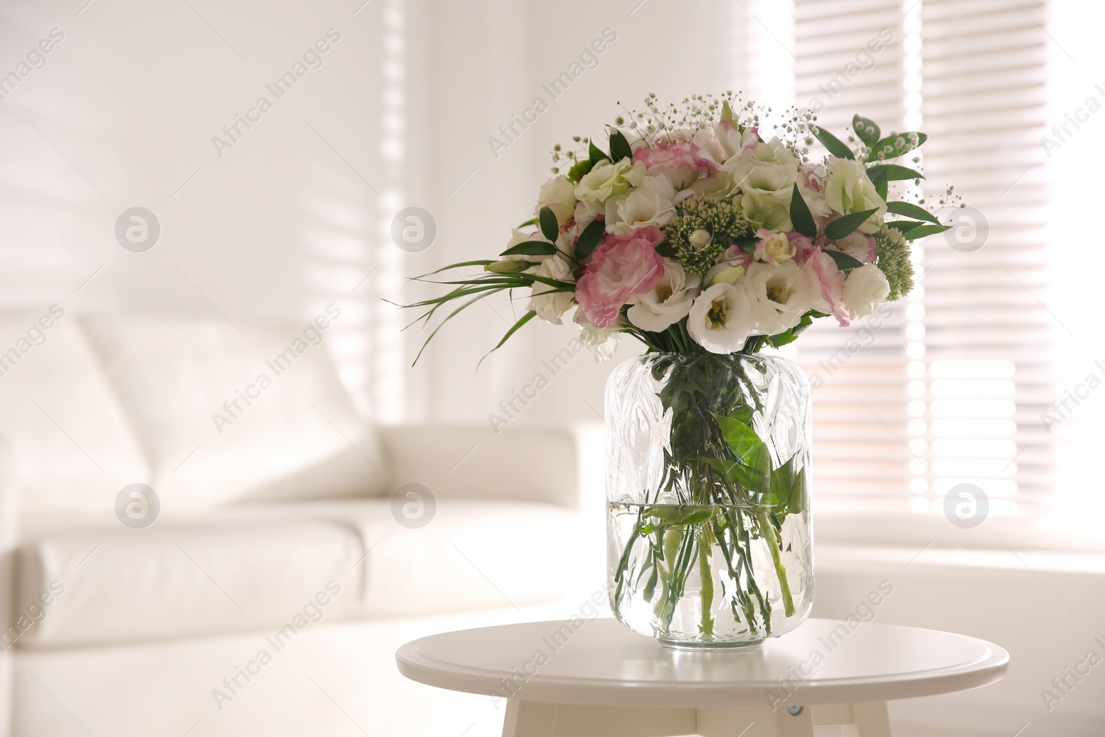 Photo of Bouquet of beautiful flowers on table in living room. Interior design