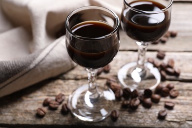 Photo of Glasses of coffee liqueur on wooden table, closeup
