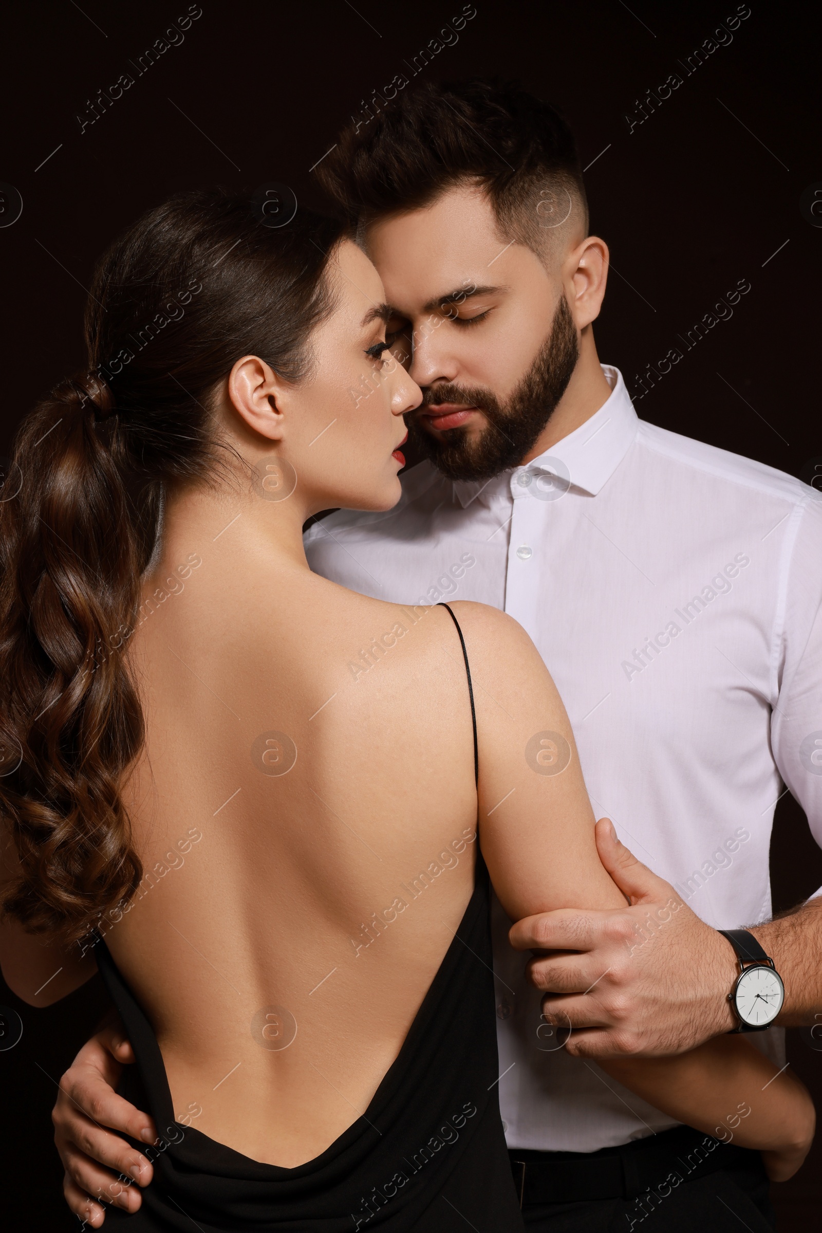 Photo of Handsome bearded man with sexy lady on dark background