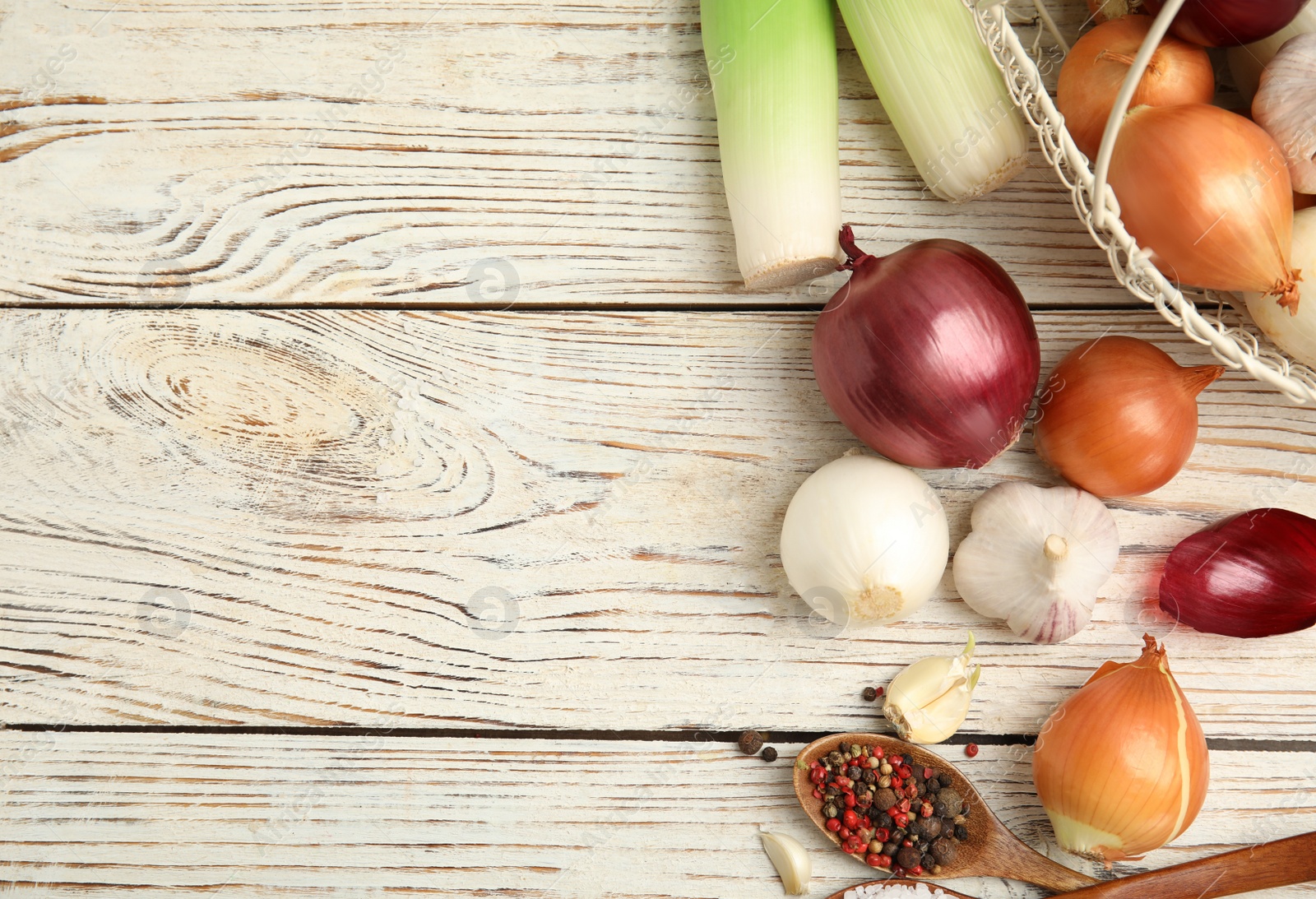 Photo of Fresh onion bulbs, leek, garlic, peppers mix and salt on white wooden table, flat lay. Space for text