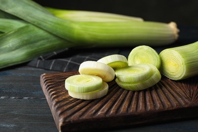 Photo of Fresh raw leek on cutting board, closeup. Ripe onion