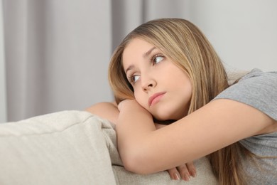 Photo of Upset teenage girl on sofa at home