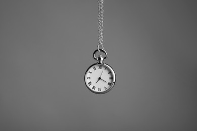 Photo of Stylish pendulum on grey background. Hypnotherapy session