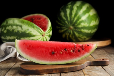 Photo of Board with yummy watermelon slice on wooden table