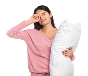 Sleepy young woman with soft pillow on white background