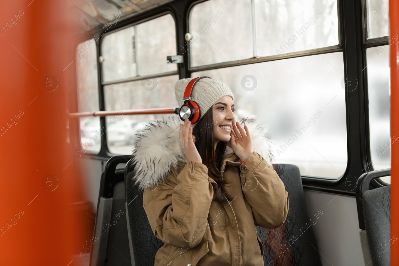 Photo of Young woman listening to music with headphones in public transport