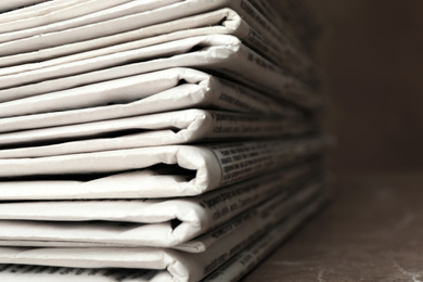 Photo of Stack of newspapers on table, closeup. Journalist's work