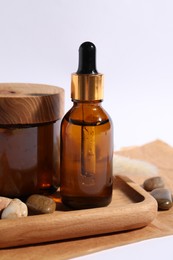 Composition with bottle of cosmetic serum on white background, closeup