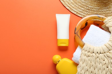 Suntan products, straw hat and bag on orange background, flat lay. Space for text