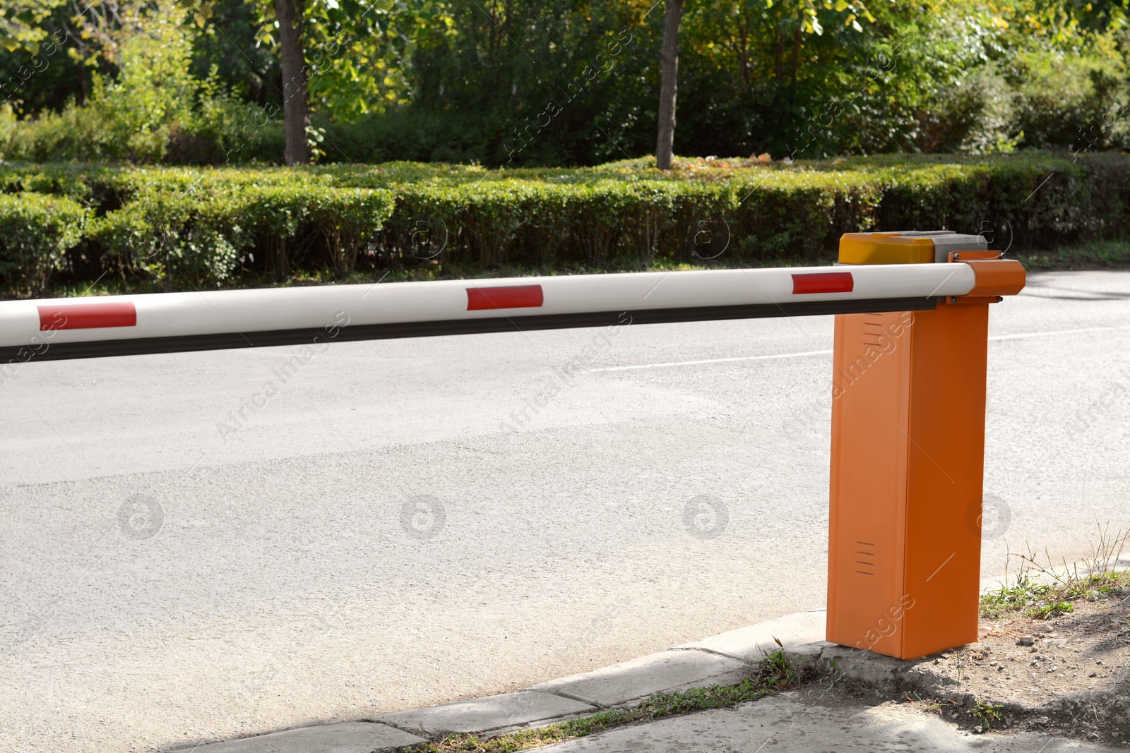 Photo of Closed boom barrier near road on sunny day