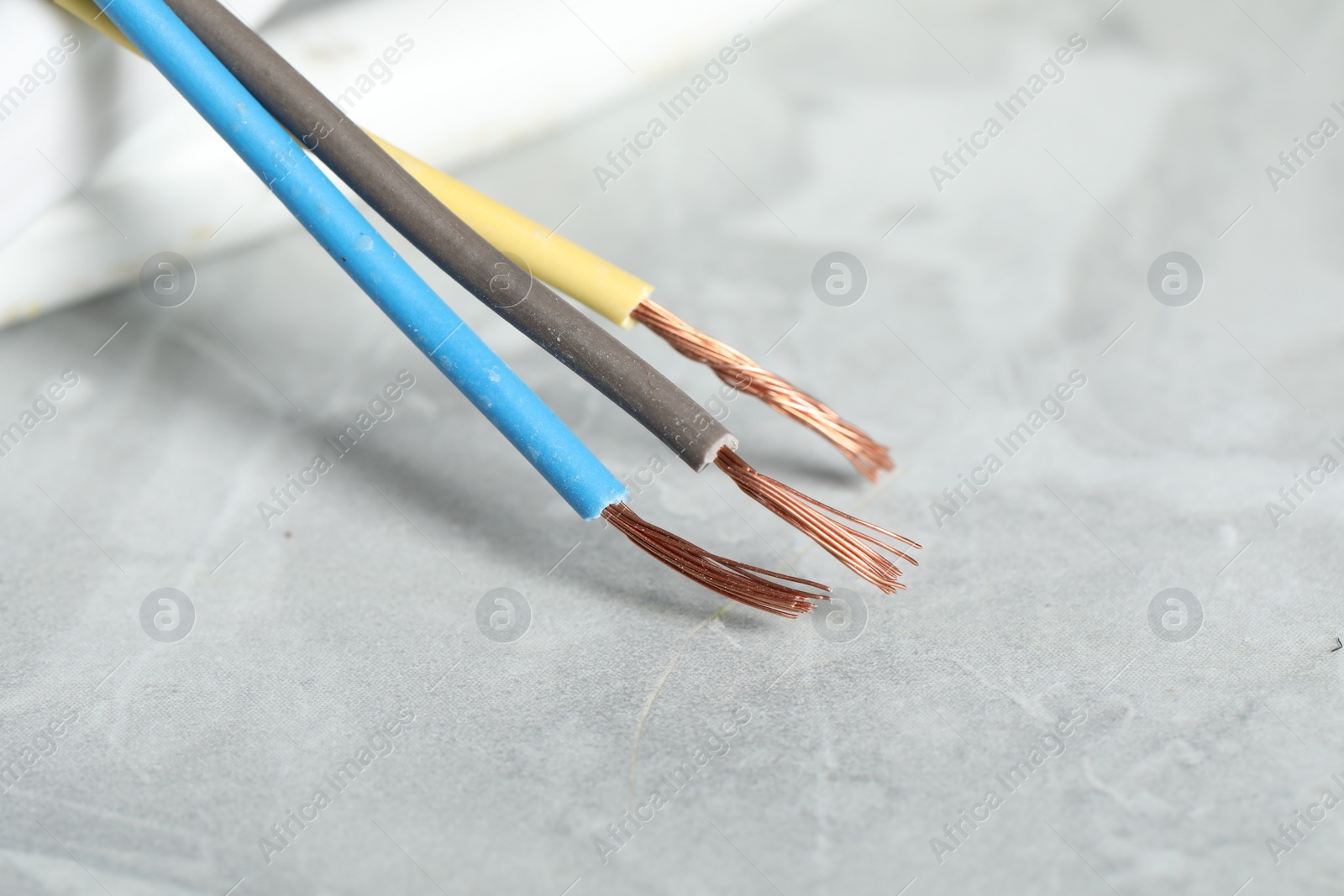 Photo of Colorful electrical wire on gray textured surface, closeup