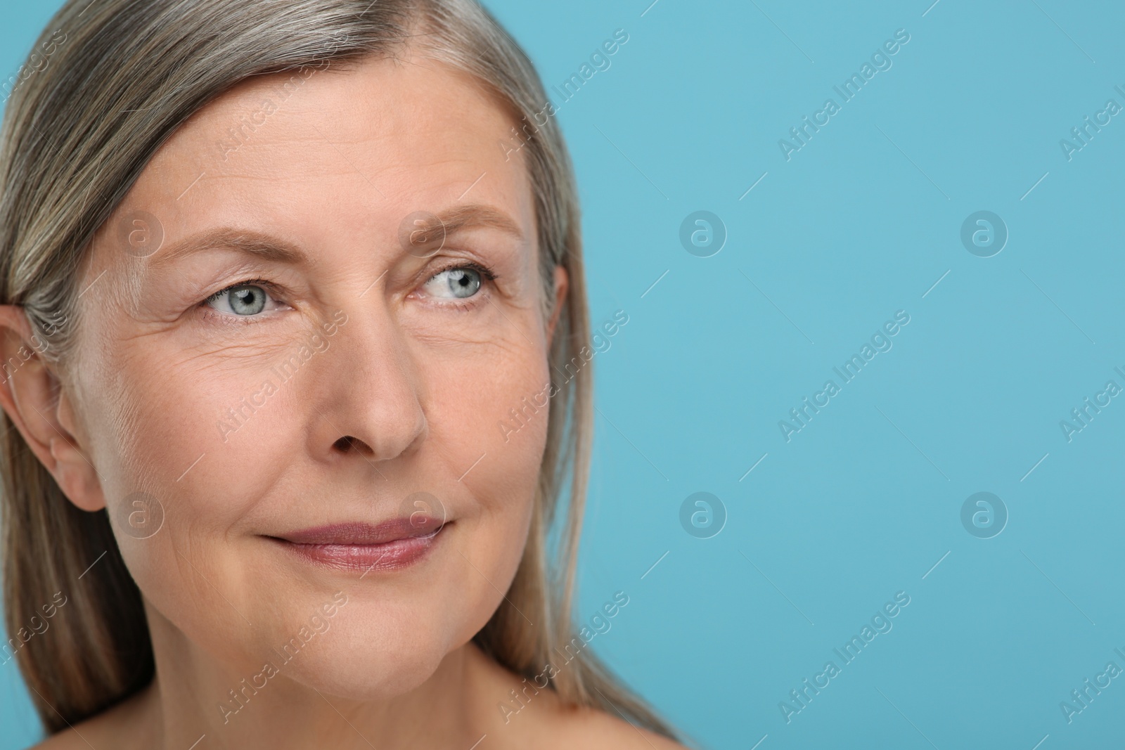 Photo of Portrait of senior woman with aging skin on light blue background, space for text. Rejuvenation treatment