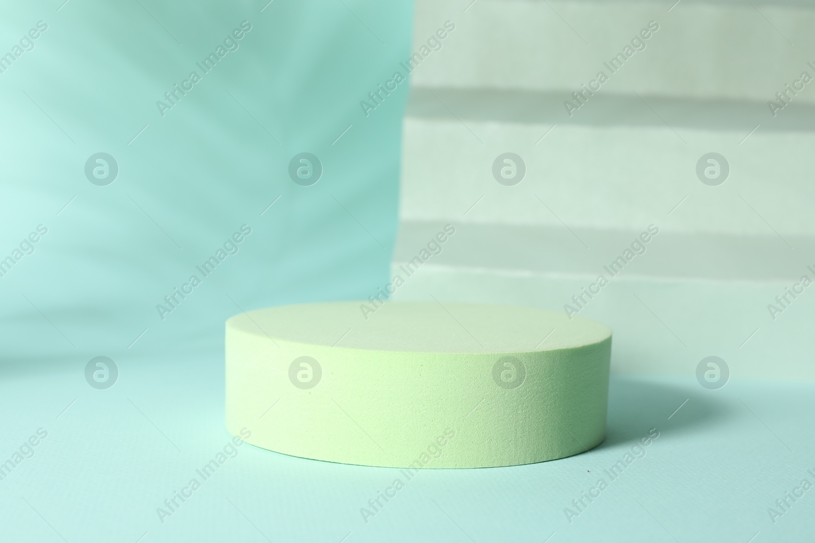 Photo of Presentation of product. Podium, paper and shadows on turquoise background. Space for text