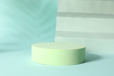 Photo of Presentation of product. Podium, paper and shadows on turquoise background. Space for text