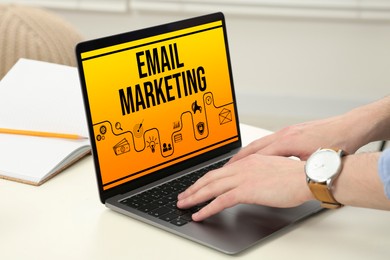 Email marketing. Man using laptop at table, closeup