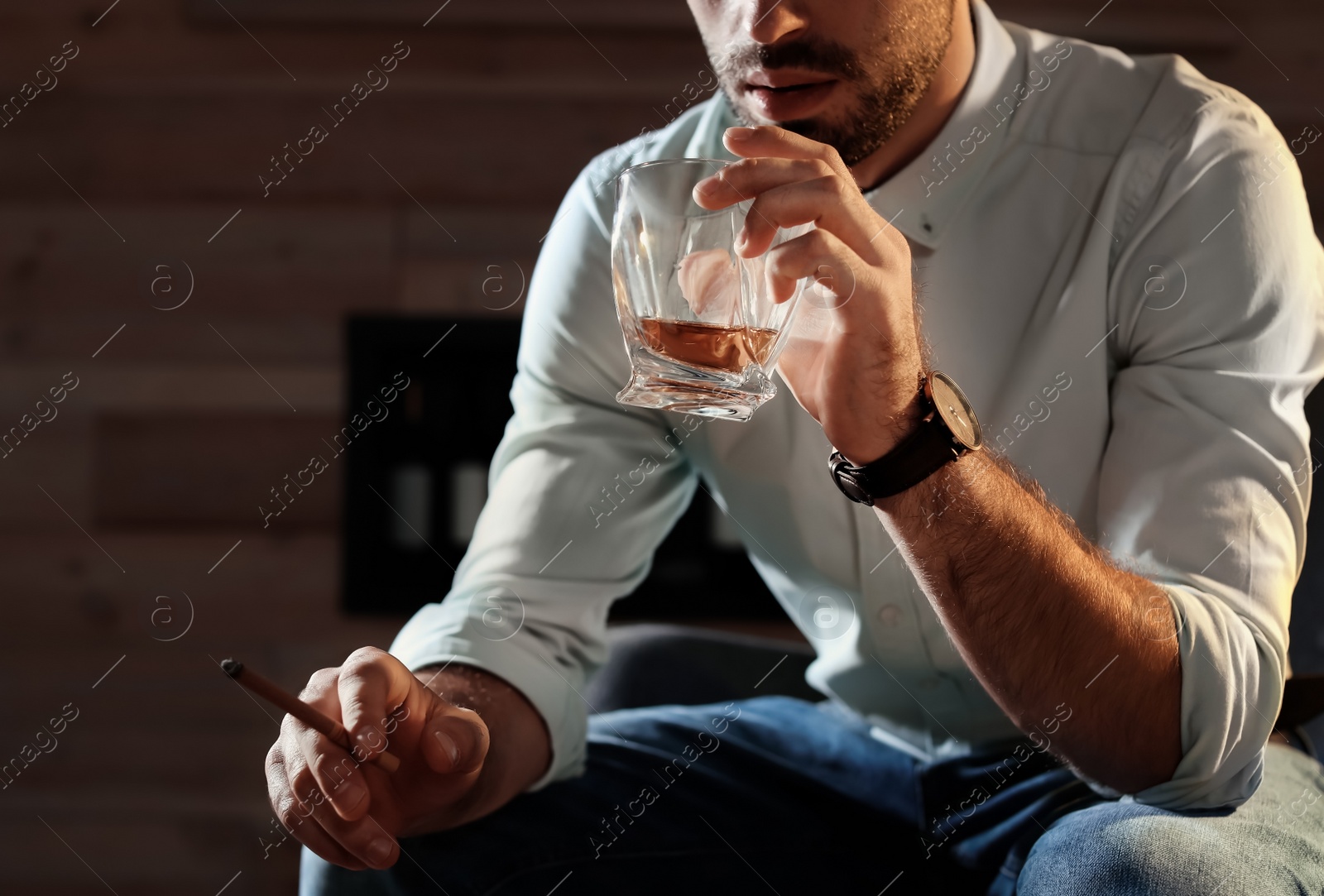 Photo of Man with glass of whiskey and cigar at home, closeup. Space for text