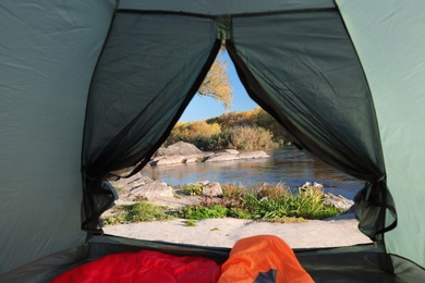 Photo of Camping tent with sleeping bags in wilderness, view from inside