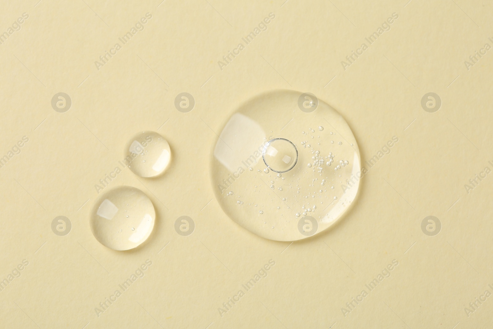 Photo of Samples of cosmetic serum on beige background, flat lay