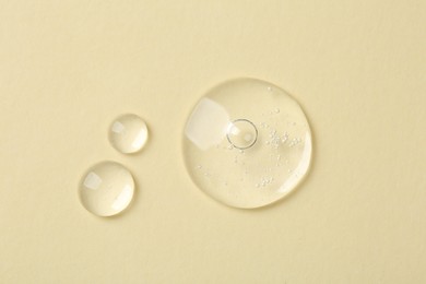 Photo of Samples of cosmetic serum on beige background, flat lay