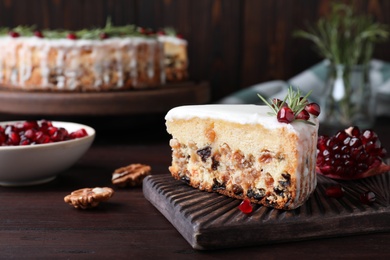 Piece of traditional homemade Christmas cake and ingredients on wooden table, closeup